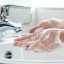 Hands with gloves washing in water