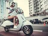 Girl riding an electric scooter. Electric scooters cut queues and emissions in urban areas and benefit from batteries with longer lifetime.