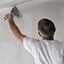 worker applying putty joining gypsum boards on wall