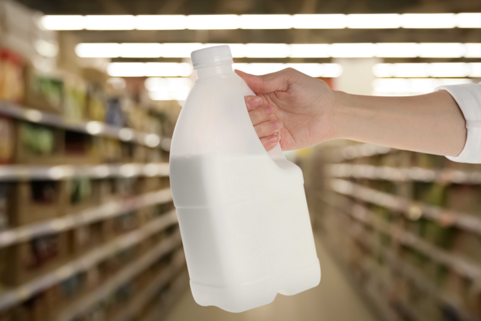 Hand is holding a 2-liter milk jar